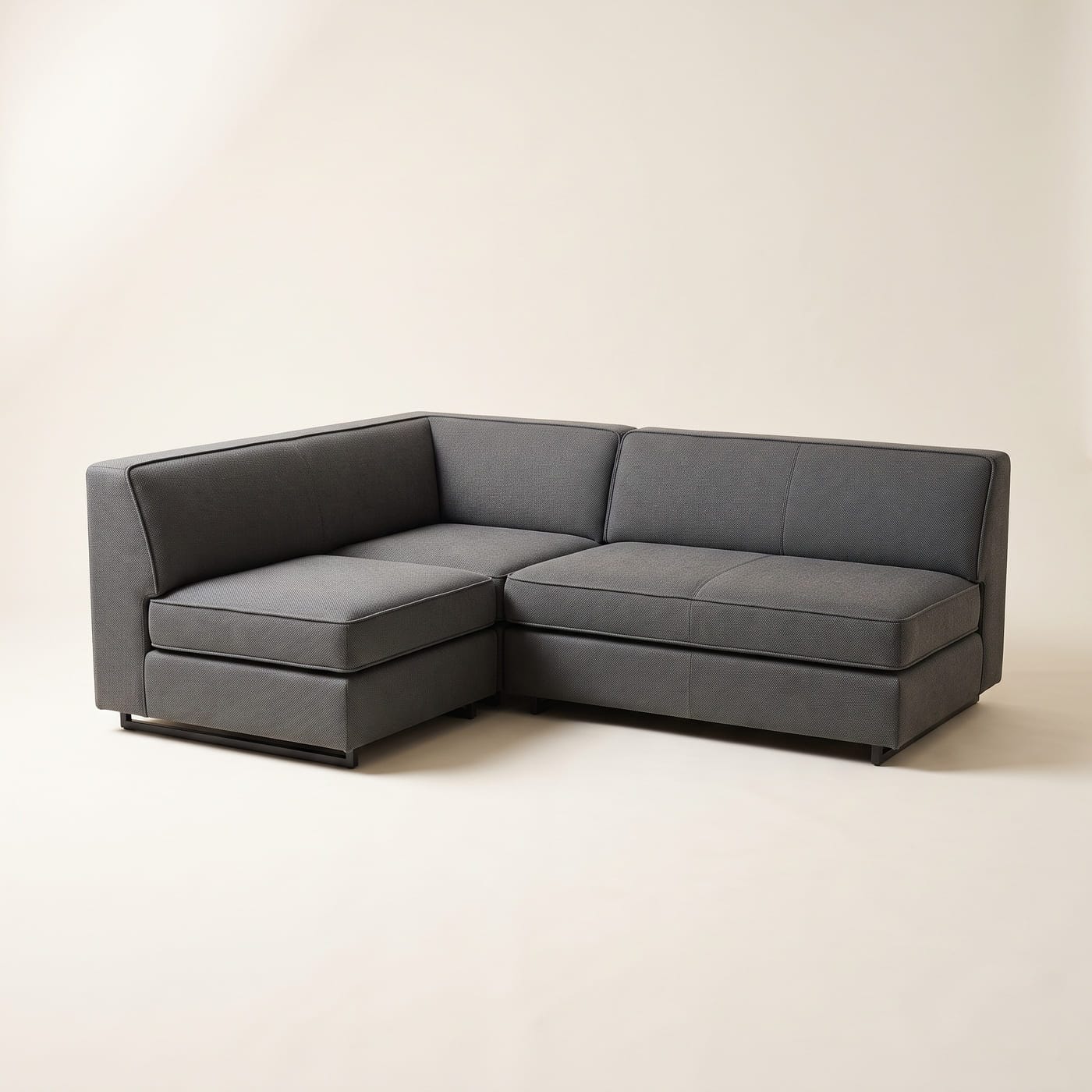 Ecksofa in graphitfarbenem Stoff mit quadratischem Eckelement und einem über Eck laufenden Rückenkissen.